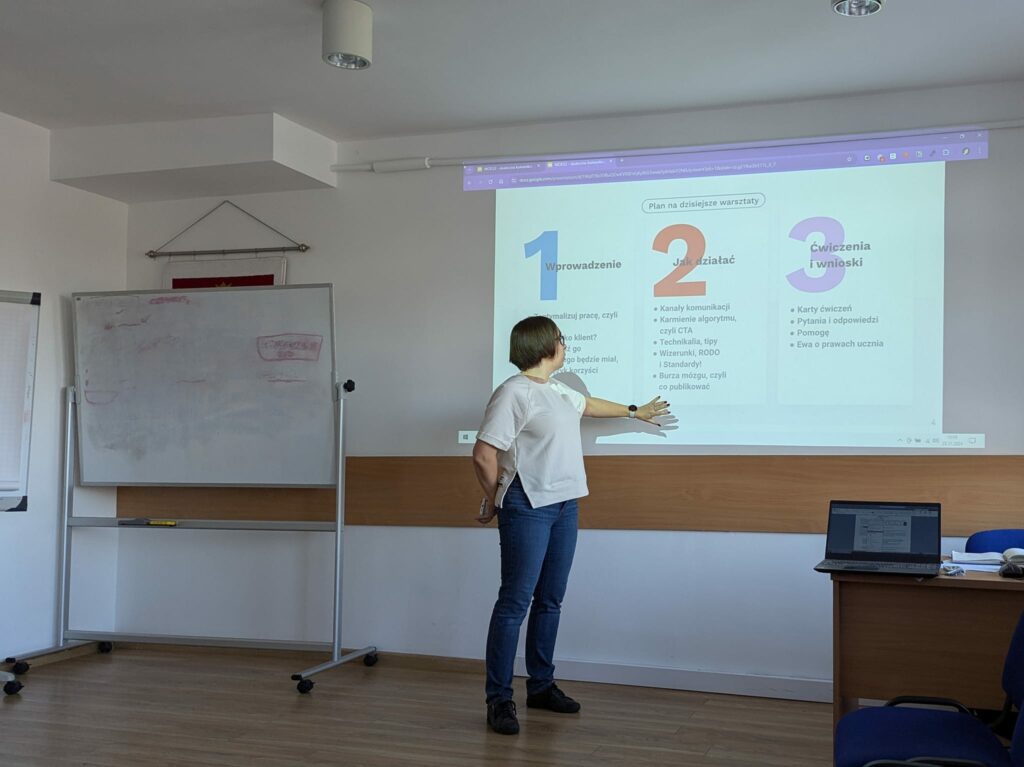 Beata Broniek przed rzutnikiem przedstawiająca plan webinaru